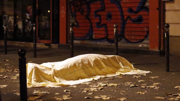 A victim under a blanket lays dead outside the Bataclan theater in Paris.