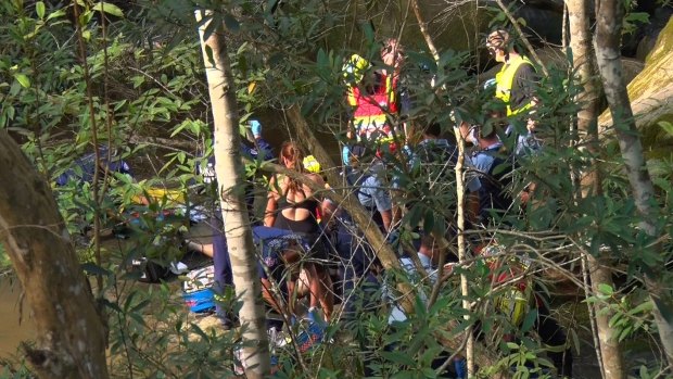 Emergency service workers try to save the life of a man who fell at Somersby Falls.