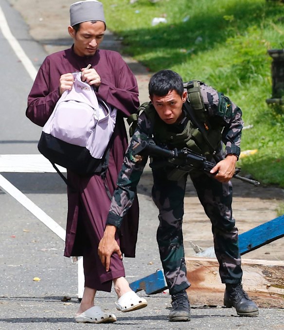 Government troops frisk a Muslim man at a checkpoint leading to Marawi city.