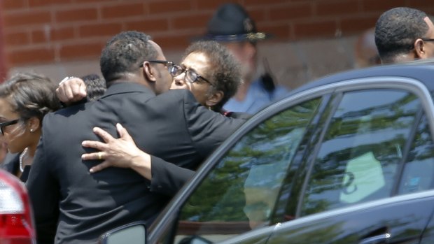 Bobby Brown hugs an unidentified woman after the funeral service.