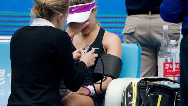 Eugenie Bouchard is assessed by an on-court medic during the China Open earlier this month. She was forced to retire.