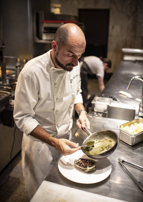 Rockpool Bar & Grill executive chef Corey Costelloe finishes a local abalone with butter.