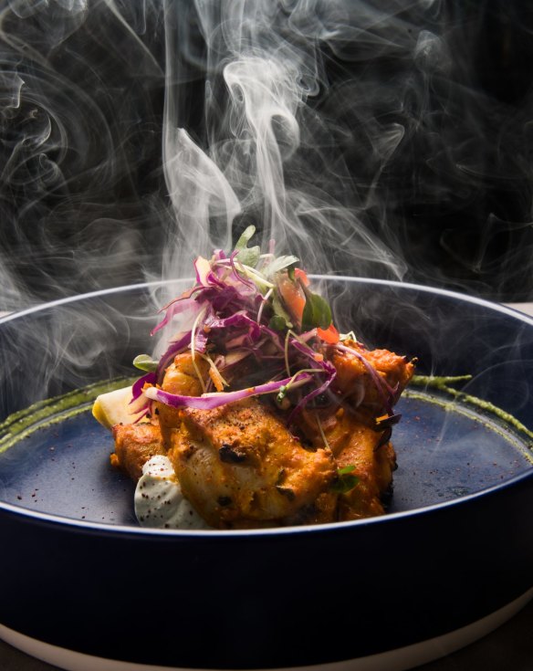 Chicken tikka is presented with a puff of smoke.