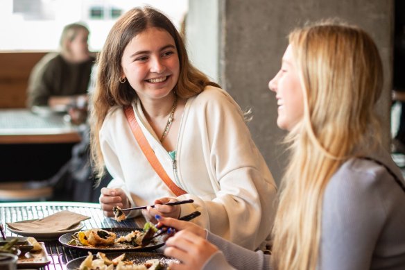 Teenagers enjoying the sushi train at Chocolate Buddha at Federation Square.