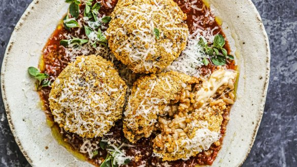 Cheesy bolognese arancini bobbing in tomato sauce.