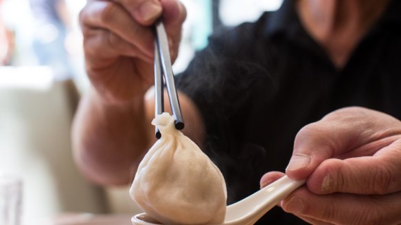 Tony Tan demonstrates how to eat xiao long bao at Shanghai Street.