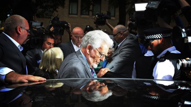 Under scrutiny: Rolf Harris is surrounded by the media during his trial in London.