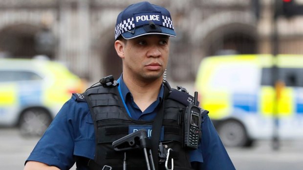 An armed police officer stands guard outside the Houses of Parliament in London.