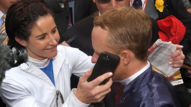 Michelle Payne puts Cup winner Kerrin McEvoy on the phone with her sister - and his wife - Cathy Payne.