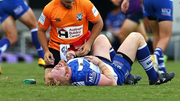 In pain: James Graham on the deck after injuring himself during the Bulldogs' trial match with the Storm.