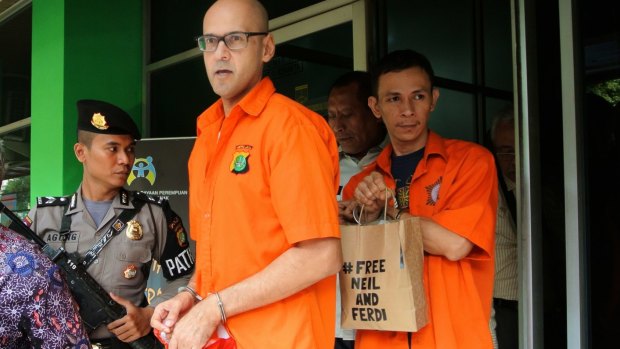Neil Bantleman and Ferdinant Tjiong leaving the police station to be transferred to prison. 