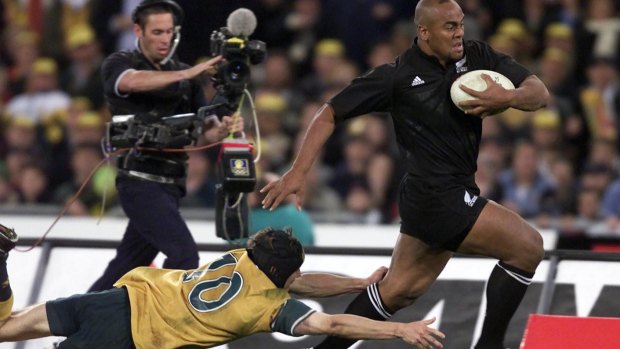 On the charge: Jonah Lomu takes on the Wallabies in front of 109,000 fans in the year 2000.