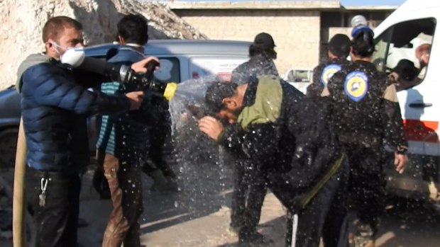 Civil defence workers spray water on victims after the chemical weapons attack near Idlib. 