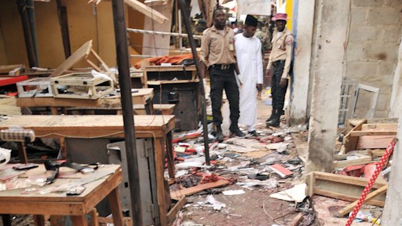 Rescue workers inspect the scene of Kano market explosion, Nigeria. .