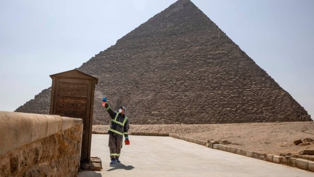 Municipal workers sanitise the Giza pyramids complex.