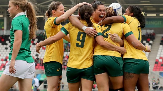Australia captain Sharni Williams celebrates with her team-mates after scoring the opening try.