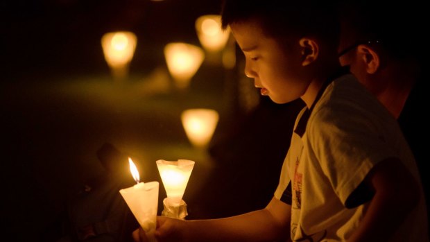 A young boy holds a candle during a candlelight vigil at Victoria Park in Hong Kong.