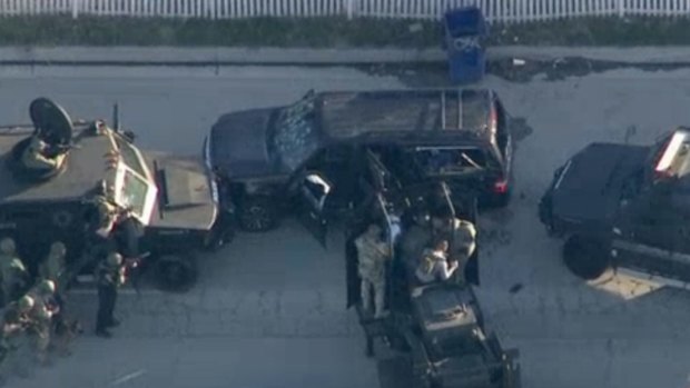 Armoured vehicles surround an SUV following the shootout.