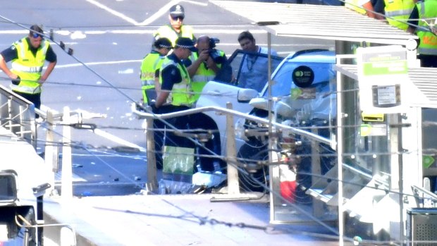 Police inspect the car at the scene of the incident.