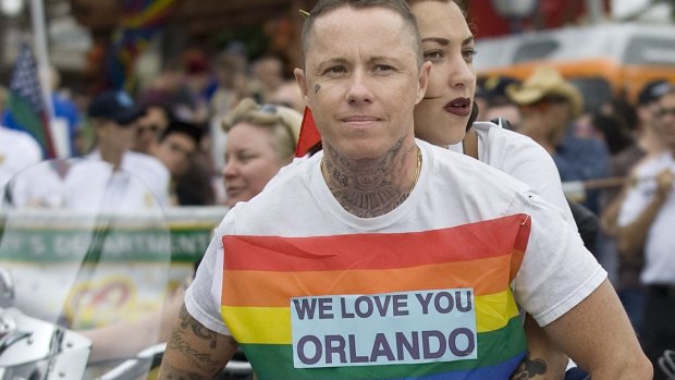 Married couple Grapes, left, and Candi Wasserman ride in West Hollywood's Gay Pride Parade on Sunday, showing support for the people who were gunned down in Orlando.