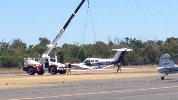A crane moves in to shift the plane at Bunbury airport.