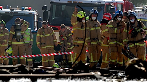 Firefighters at the scene of the plane crash at the Essendon DFO. 