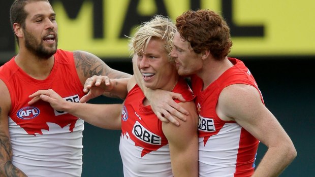 Isaac Heeney celebrates a goal with Lance Franklin and Gary Rohan.