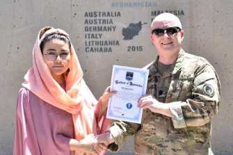 In this undated photo, Zainab Azizi receives a Certificate of Appreciation from a US Army member.