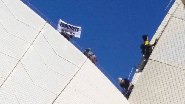 Protesters raise a sign on one of the sails of the Opera House, calling for the Manus Island detainees to be resettled in Australia.