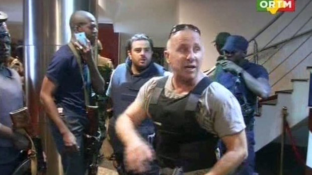 In this image taken from Mali's ORTM television channel, a security officer gives instructions to other security forces before moving against Islamist gunmen inside the Radisson Blu Hotel in Bamako, Mali.