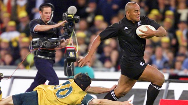 Might and power: Jonah Lomu evades Stephen Larkham during the memorable 39-35 win over the Wallabies at Stadium Australia in July, 2000.