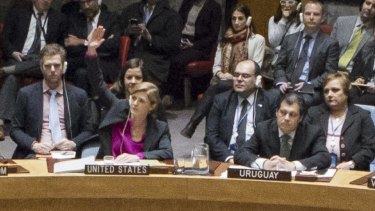 US ambassador to the UN Samantha Power, centre, raises her hand to abstain during the UN Security Council vote on 23 December.