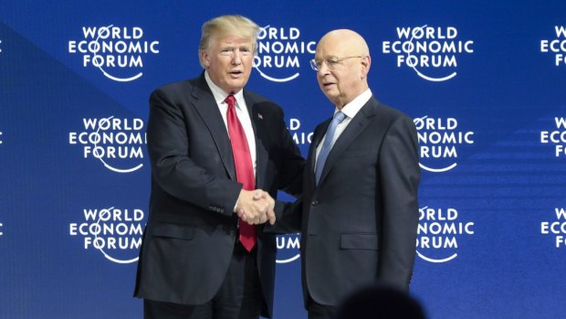 U.S. President Donald Trump, left, shakes hands with World Economic Forum chairman Klaus Schwab, 