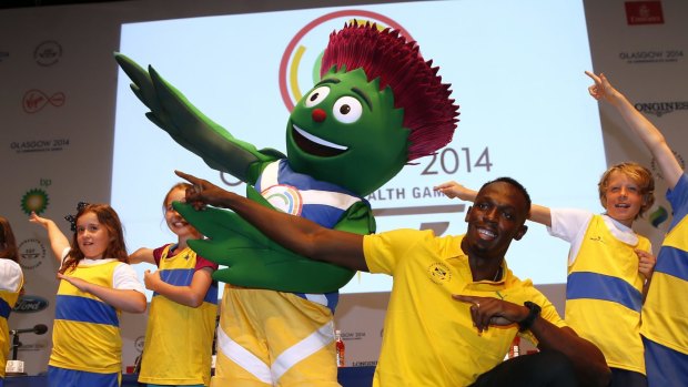 Usain Bolt of Jamaica and double Olympic champion at the 100 and 200 meters, poses with local schoolchildren and the mascot of the Commonwealth Games 'Clyde' at a press conference on the main press centre for the Commonwealth Games Glasgow 2014, in Glasgow, Scotland, Saturday, July, 26, 2014. (AP Photo/Alastair Grant)