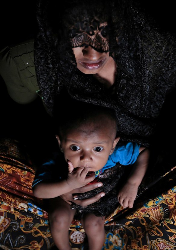 Mohsena Begum, a Rohingya who escaped to Bangladesh from Myanmar, holds her child at an unregistered refugee camp in Teknaf, near Cox's Bazar, in Bangladesh.