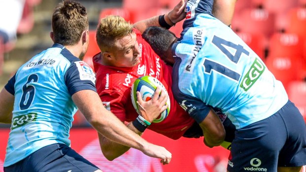 Ruan Ackermann of the Lions is upended by Waratahs Jack Dempsey and Reece Robinson in Johannesburg on Saturday.