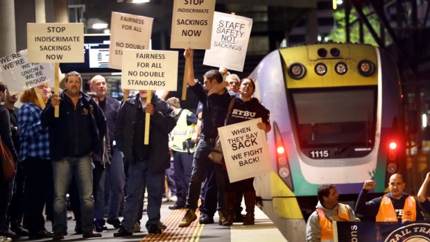 Rail, tram and bus union members protest by stopping a train at Southern Cross Station in July last year.