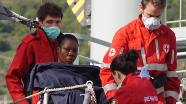 A migrant is helped by Red Cross personnel to disembark from the Spanish ship Cantabria in Salerno, Italy, last week.