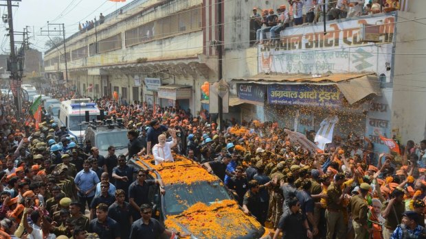 Indian Prime Minister Narendra Modi waves to supporters as he campaigns for his party in Varanasi, Uttar Pradesh.