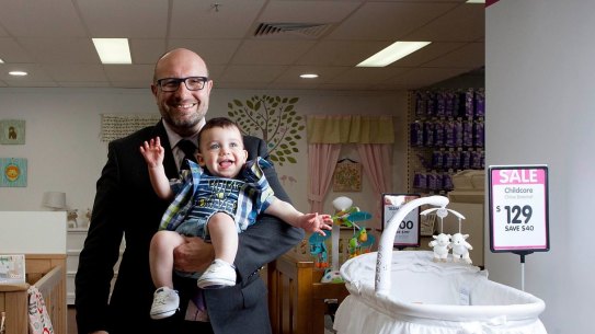 Hands full: Baby Bunting CEO Matt Spencer posing for a photo with baby Oscar James Parnall before the retailer's sharemarket listing.