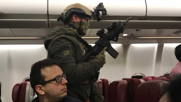 Police storm flight MH128 after a man allegedly tried to enter the cockpit.