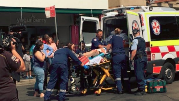 A teenage boy is loaded into an ambulance after reportedly being stabbed outside Westpoint Blacktown.