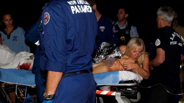 Paramedics treat Brett Connellan at Bombo Beach after the attack. 