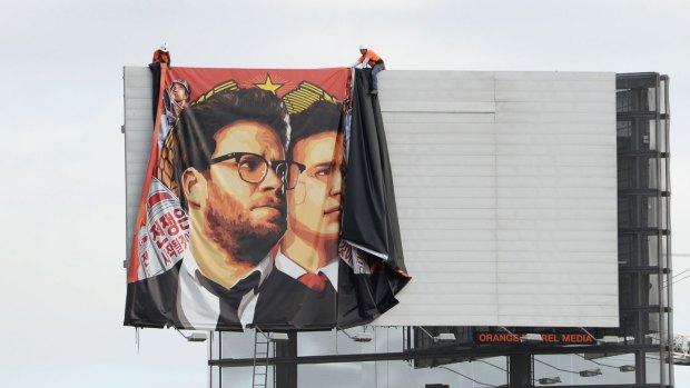 Workers remove a banner poster for the film from a Hollywood billboard on Thursday.