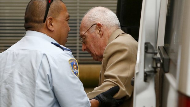 A correctional officer escorts Roger Rogerson to court for his murder trial last week. 
