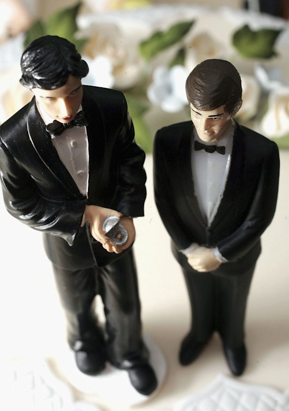 Same sex statues adorn the top of a wedding cake at a wedding specialists store in England.