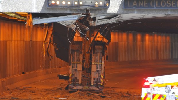 An excavator on the back of a low loader ripped 60m of tiles from the ceiling of the Parkes Way tunnel.