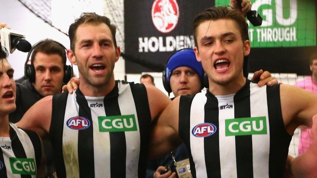 Darcy Moore sings the club song with former teammate Travis Cloke after a win in 2016. 