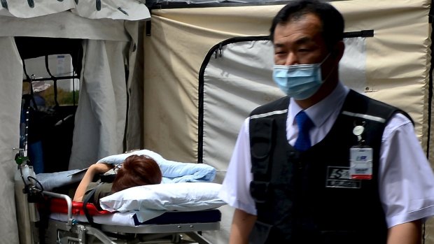 A woman believed to be infected with MERS lies on a stretcher in quarantine in Seoul.