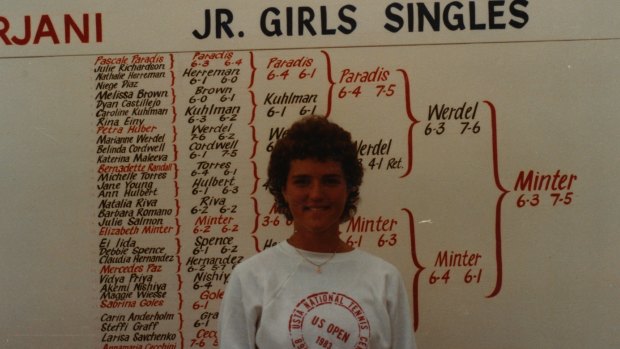 Minter in front of the US Open junior championship board. 
